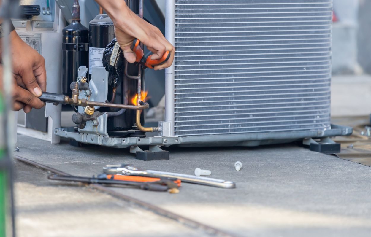 Close up of Air Conditioning Repair team use fuel gases and oxygen to weld or cut metals, Oxy-fuel welding and oxy-fuel cutting processes, repairman on the floor fixing air conditioning system See Less